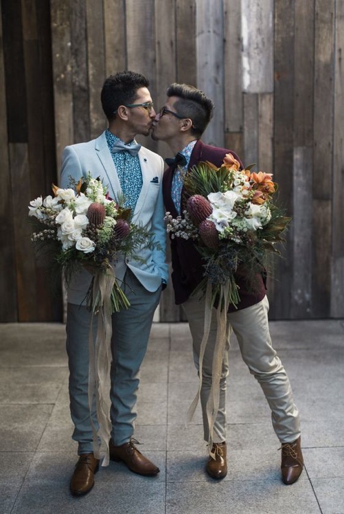 Two grooms coordinate same-sex wedding looks with complementary tuxedos