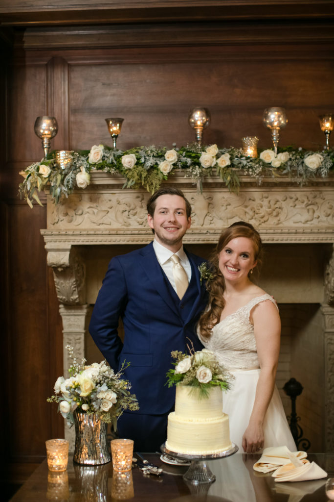 Bride and groom pose in front of fire place at one of the best places to have your winter wedding