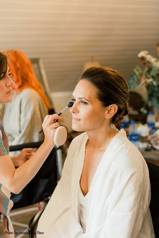 Bride getting her makeup done before the ceremony
