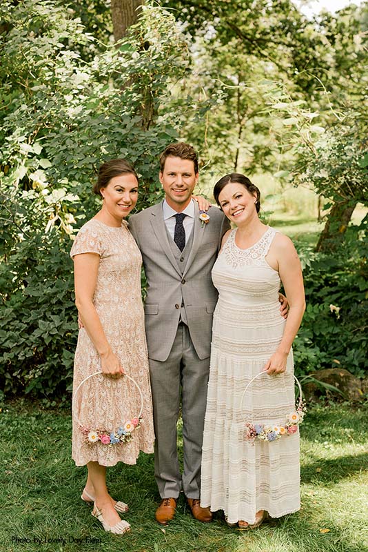 Groom and his sisters posing before the Minnesota wedding