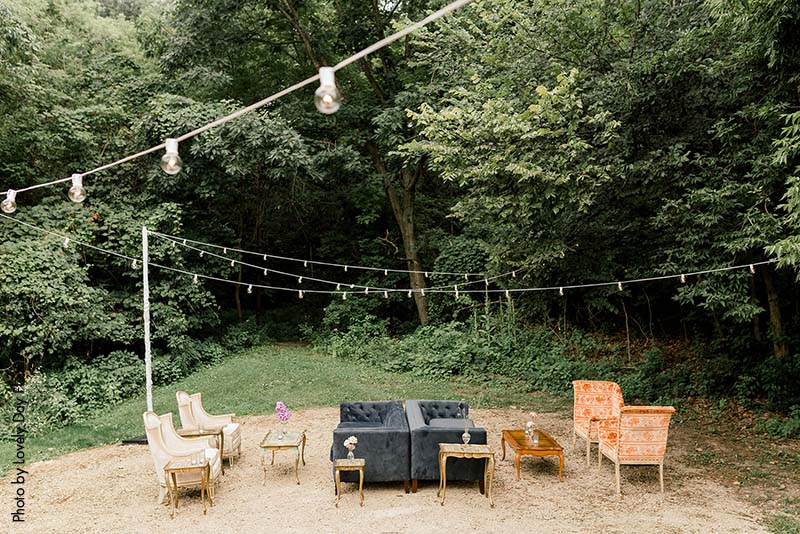 Outdoor rustic wedding lounge with chairs and coffee tables