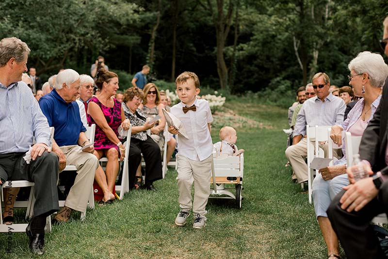 Ring bearer pulling his little brother in a wagon down the aisle