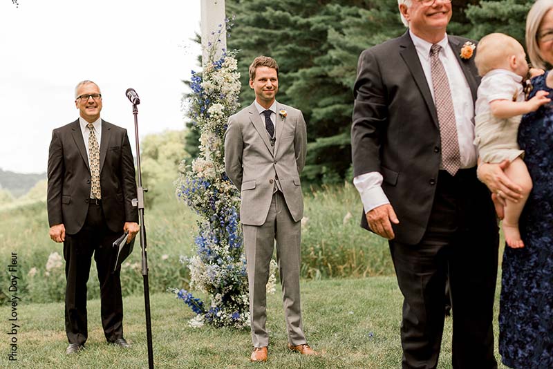 Groom waits for bride during wedding ceremony at Round Barn Farm