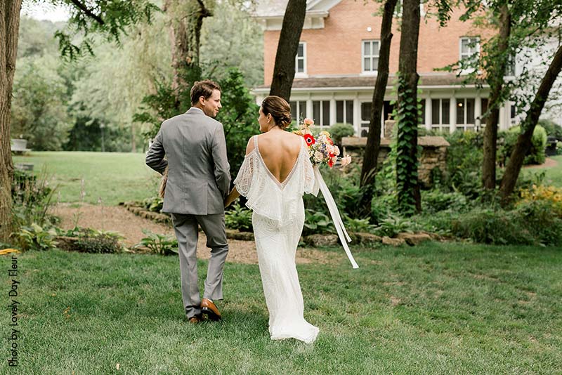 Bride in white boho dress and groom in gray suit after ceremony