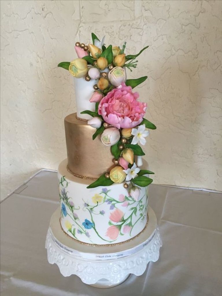 White and gold wedding cake with painted flowers