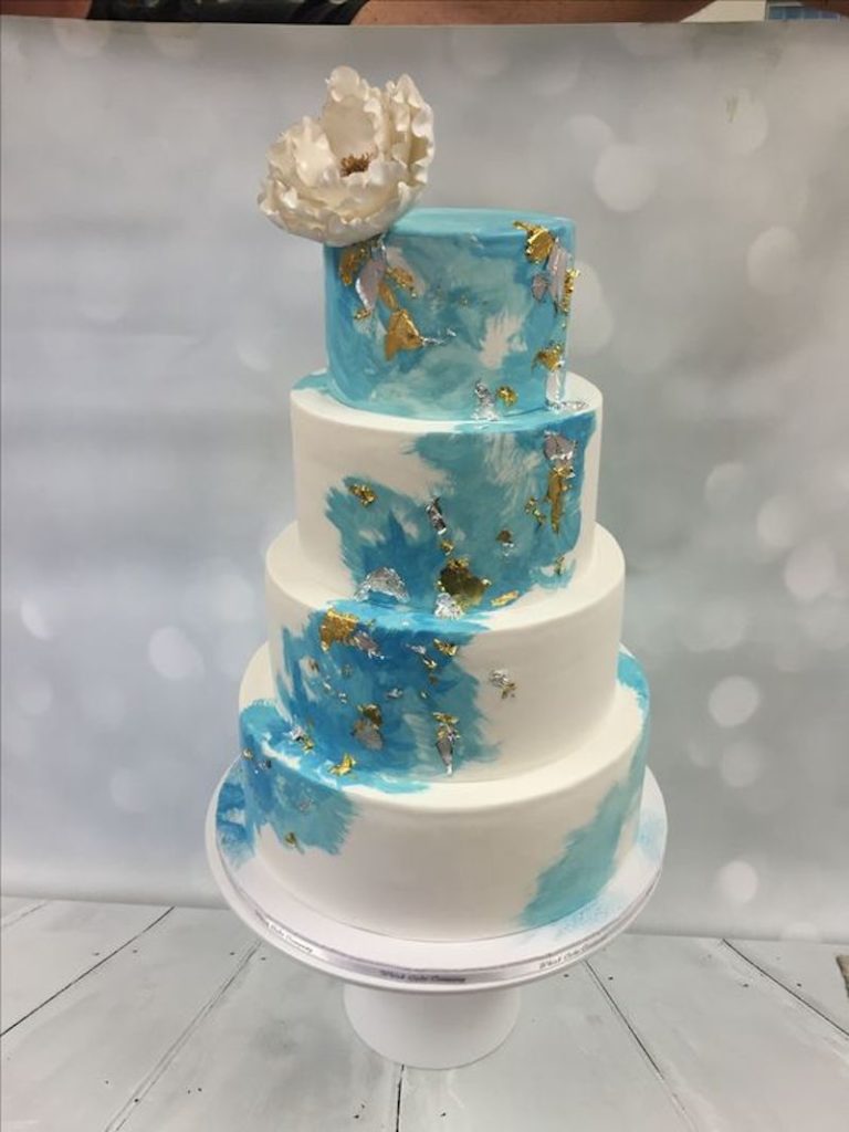 Blue and white wedding cake with gold flakes