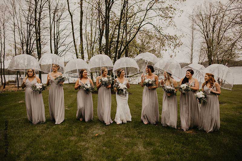 Bride and bridesmaids handle unpredictable weather with umbrellas