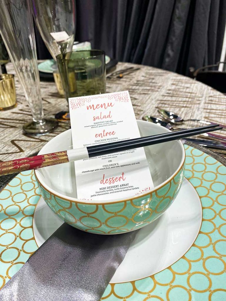 Gold and green wedding plates with chopsticks