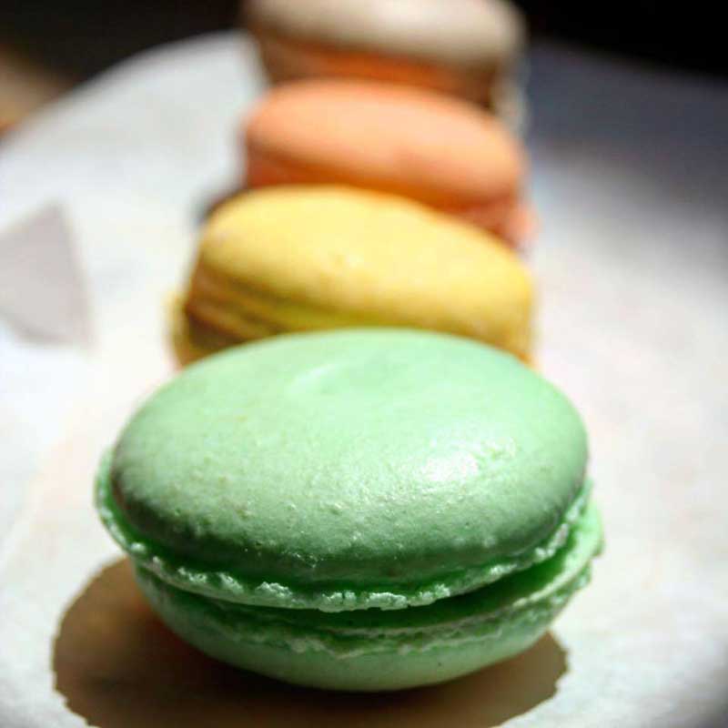 Green, yellow, and orange French Macarons for wedding dessert