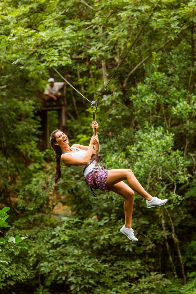 Woman zip lines over Cenote Xcanche in the State of Yucatan