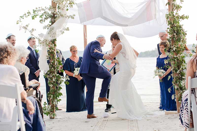 Bride and groom break glass in traditional jewish wedding ceremony