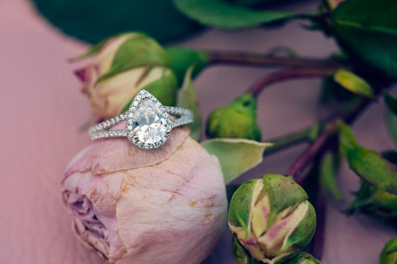 White gold engagement ring on pink flower