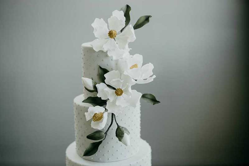 White wedding cake with white and yellow flowers