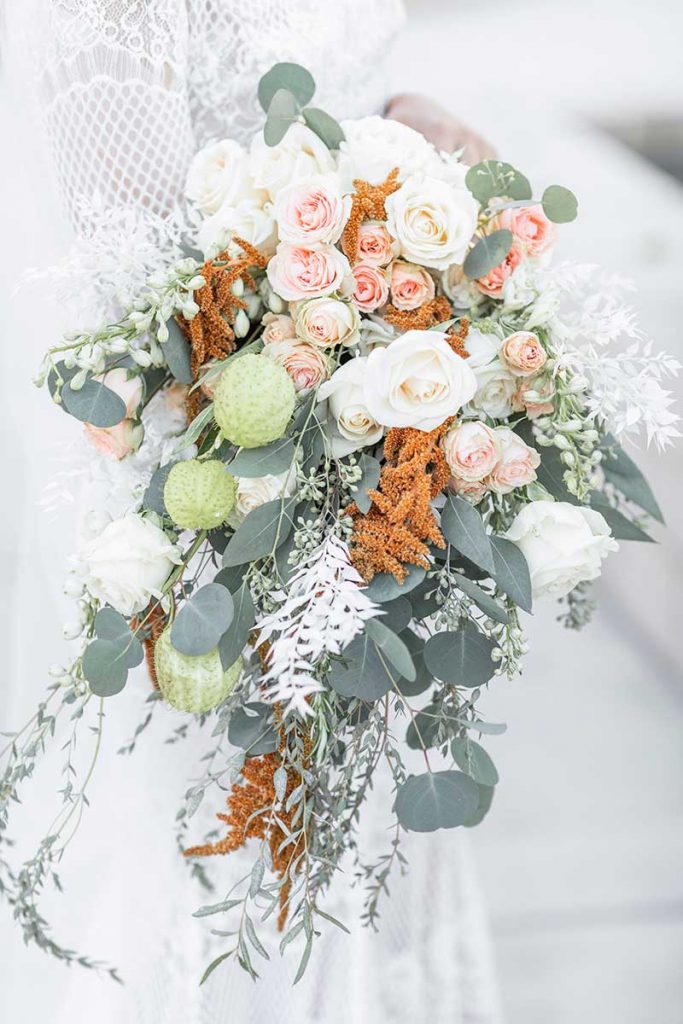 Bouquet with roses, eucalyptus, orange, and pink flowers