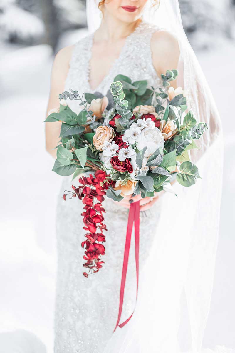 Winter bouquet with rose, eucalyptus, and pops of orange and red