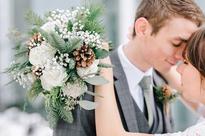 Winter bouquets with pine cones, roses, and pine needles