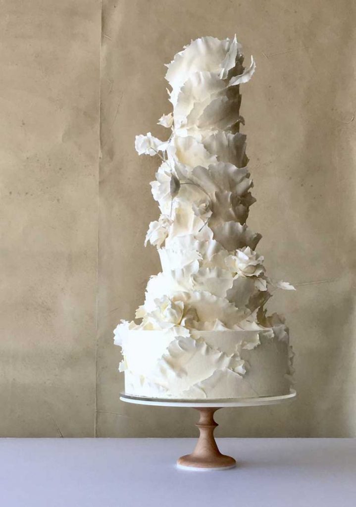 5-tier white wedding cake with thin paper flowers