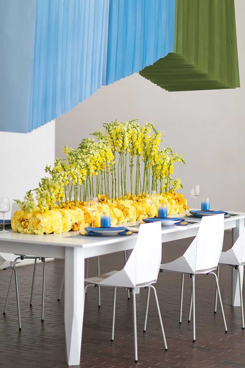 Modern wedding table with mod white chairs and yellow floral centerpiece