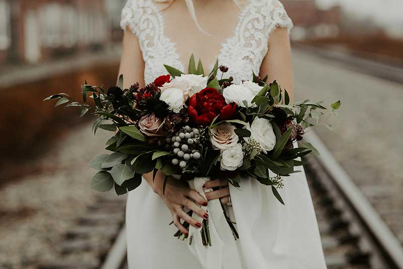 Moody wedding bouquet with red and white roses and berries