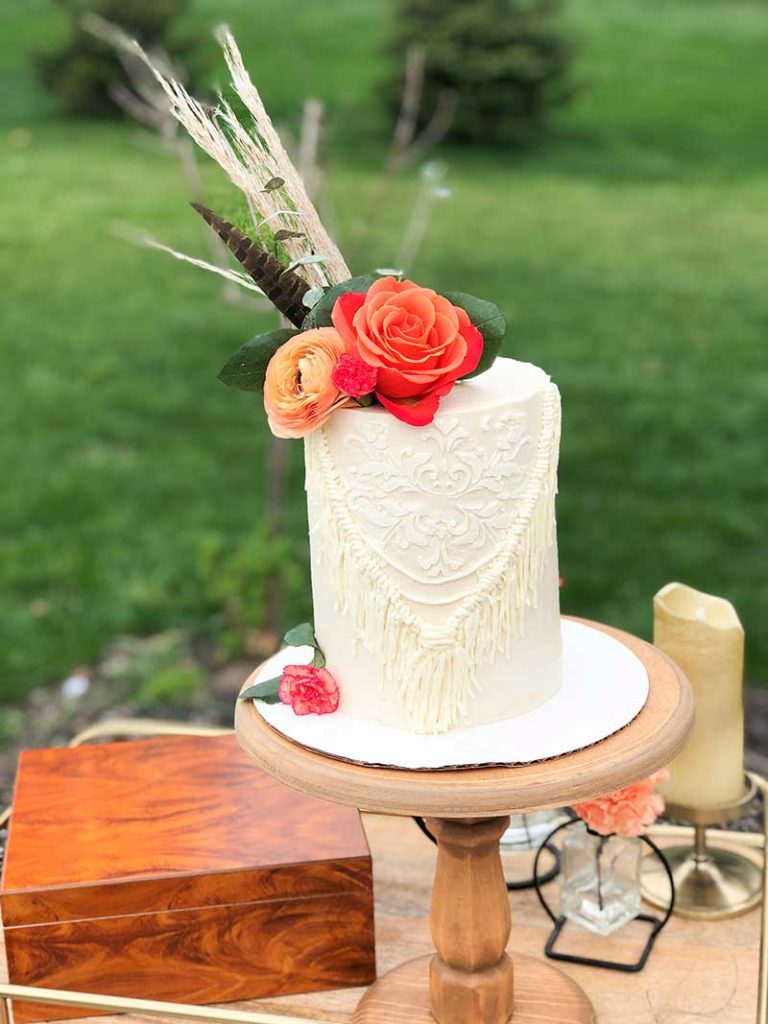 Single-tier boho wedding cake with florals on top
