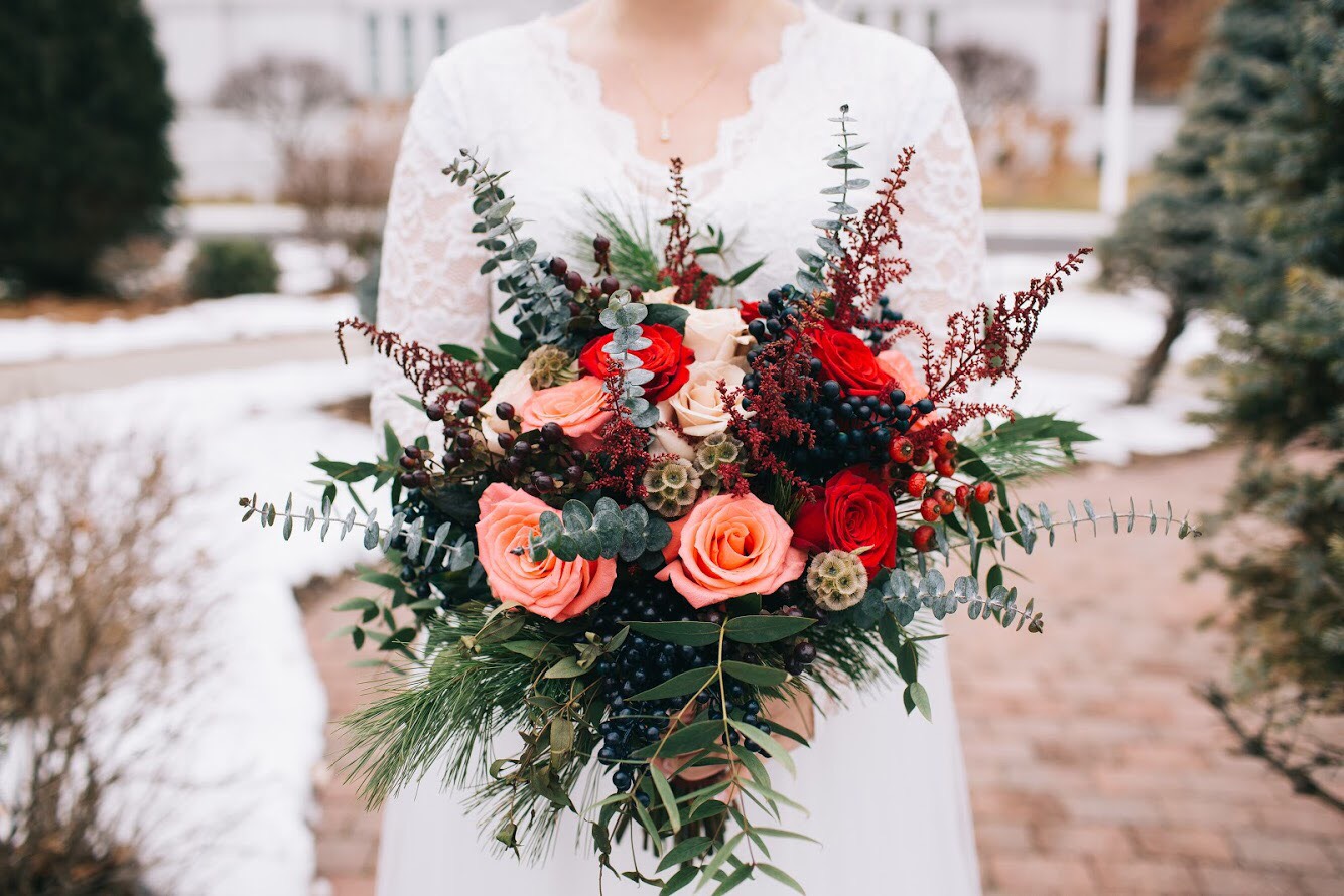Pink, red, and greenery winter bouquet by Renning's Flowers