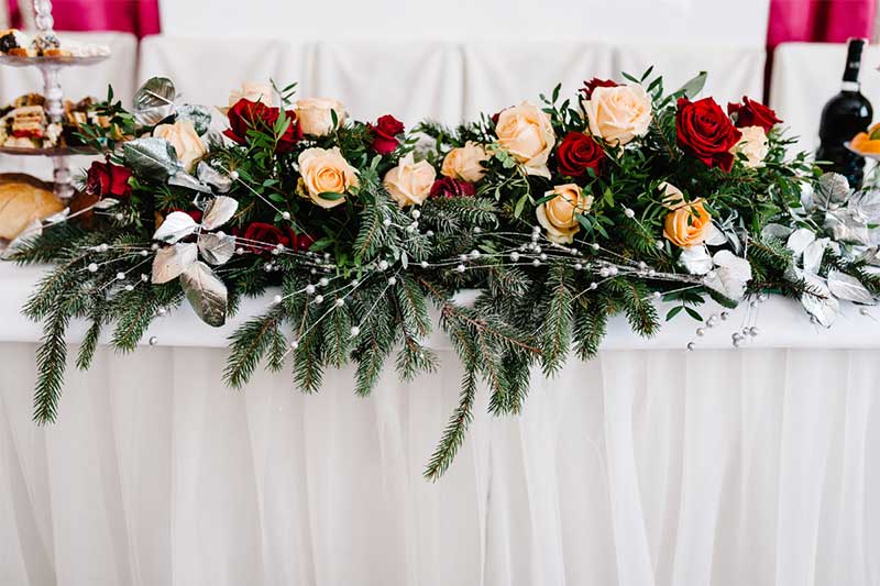 Tabletop floral garland with red and peach roses and berries