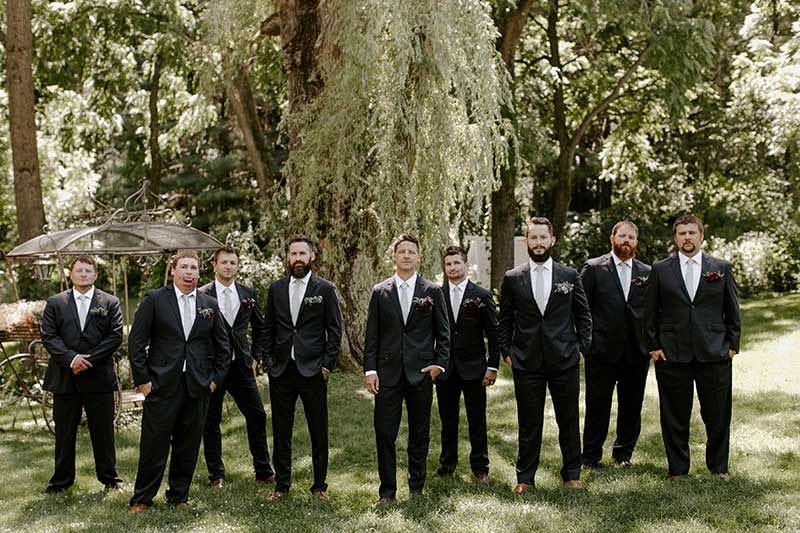 Groomsmen stand in row in navy suits