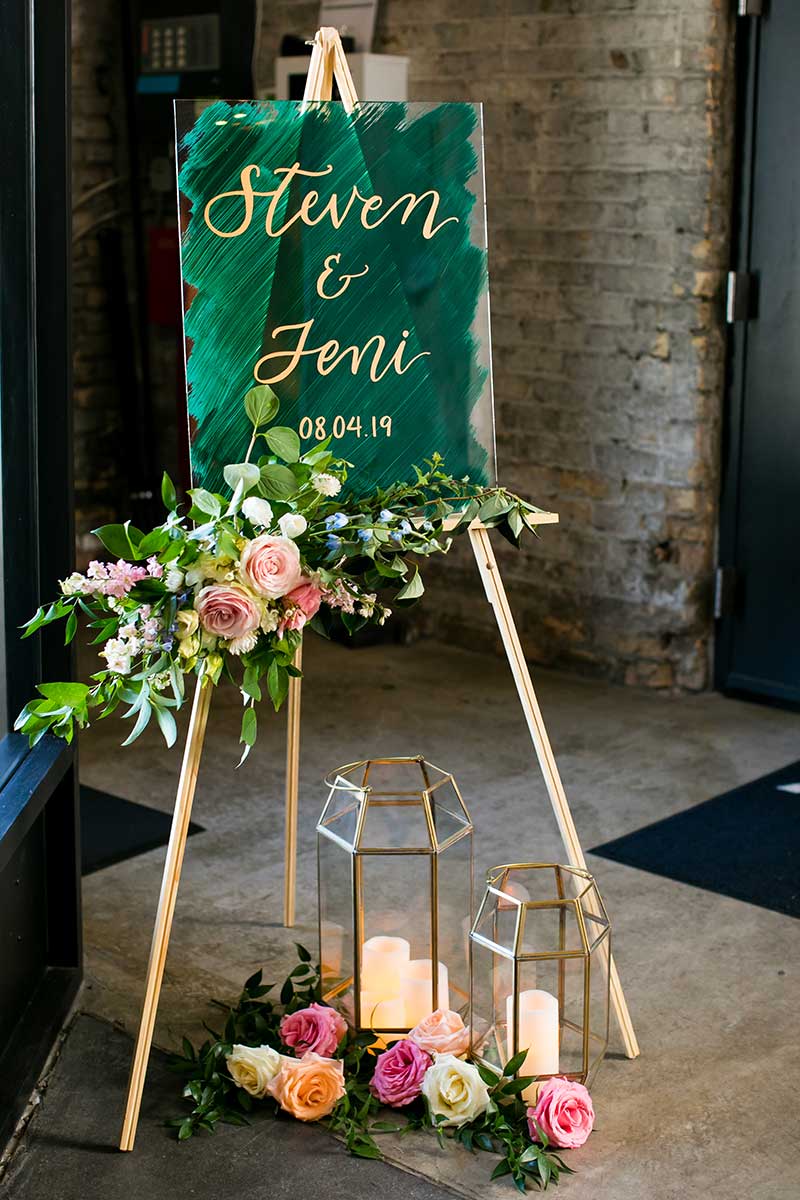 Dark green wedding welcome sign with gold calligraphy writing