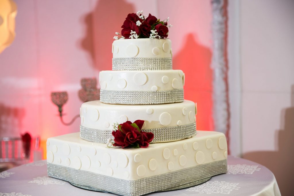 White wedding cake with white dots and red flowers