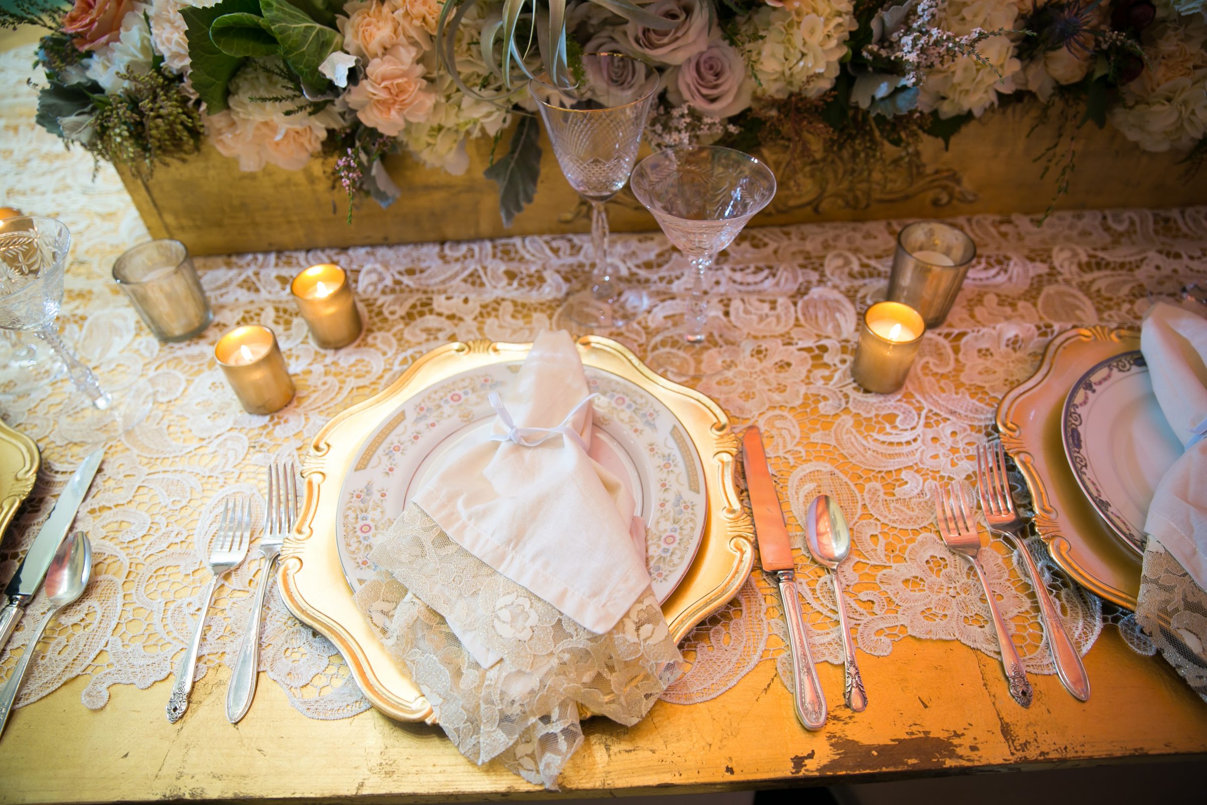 Gold wedding charger with vintage plate and napkin on top 