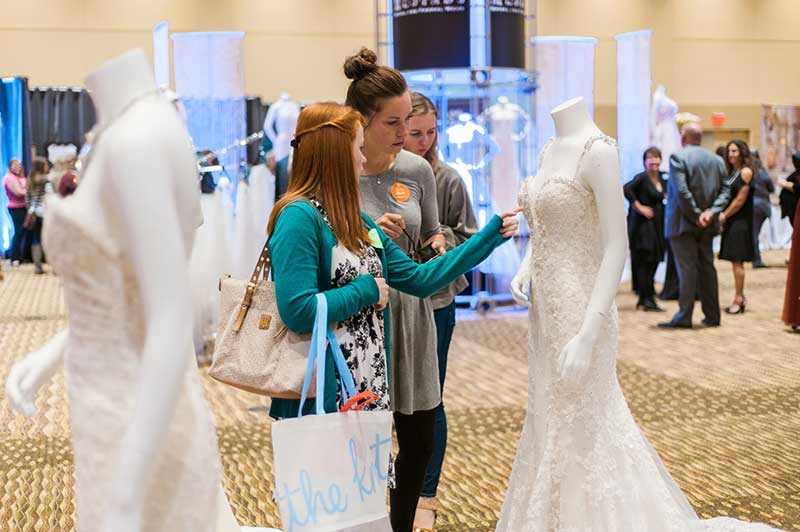 Bride looks at dresses at Unveiled Rochester 2021