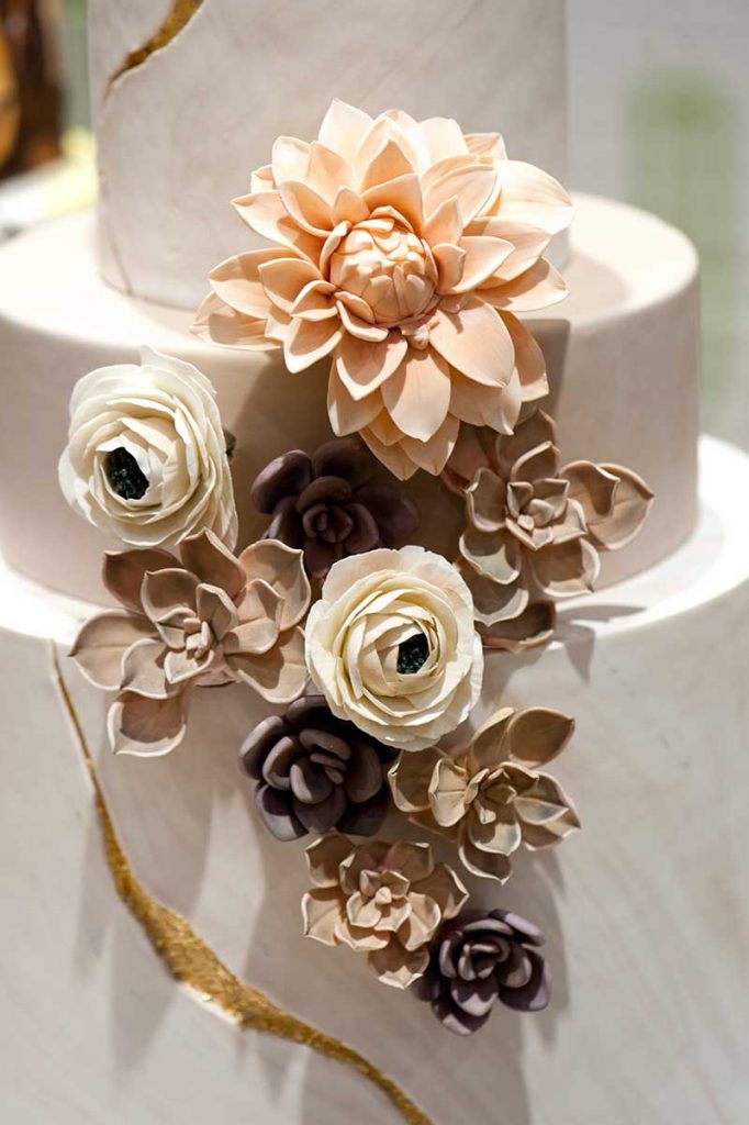 Paper flower wedding cake with blush, beige, and white flowers
