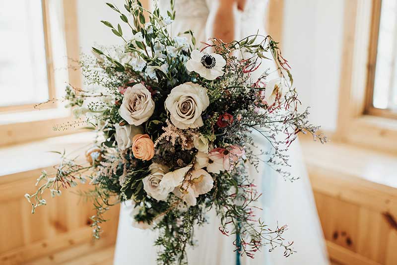Moody bridal bouquet with anemone, roses, greenery