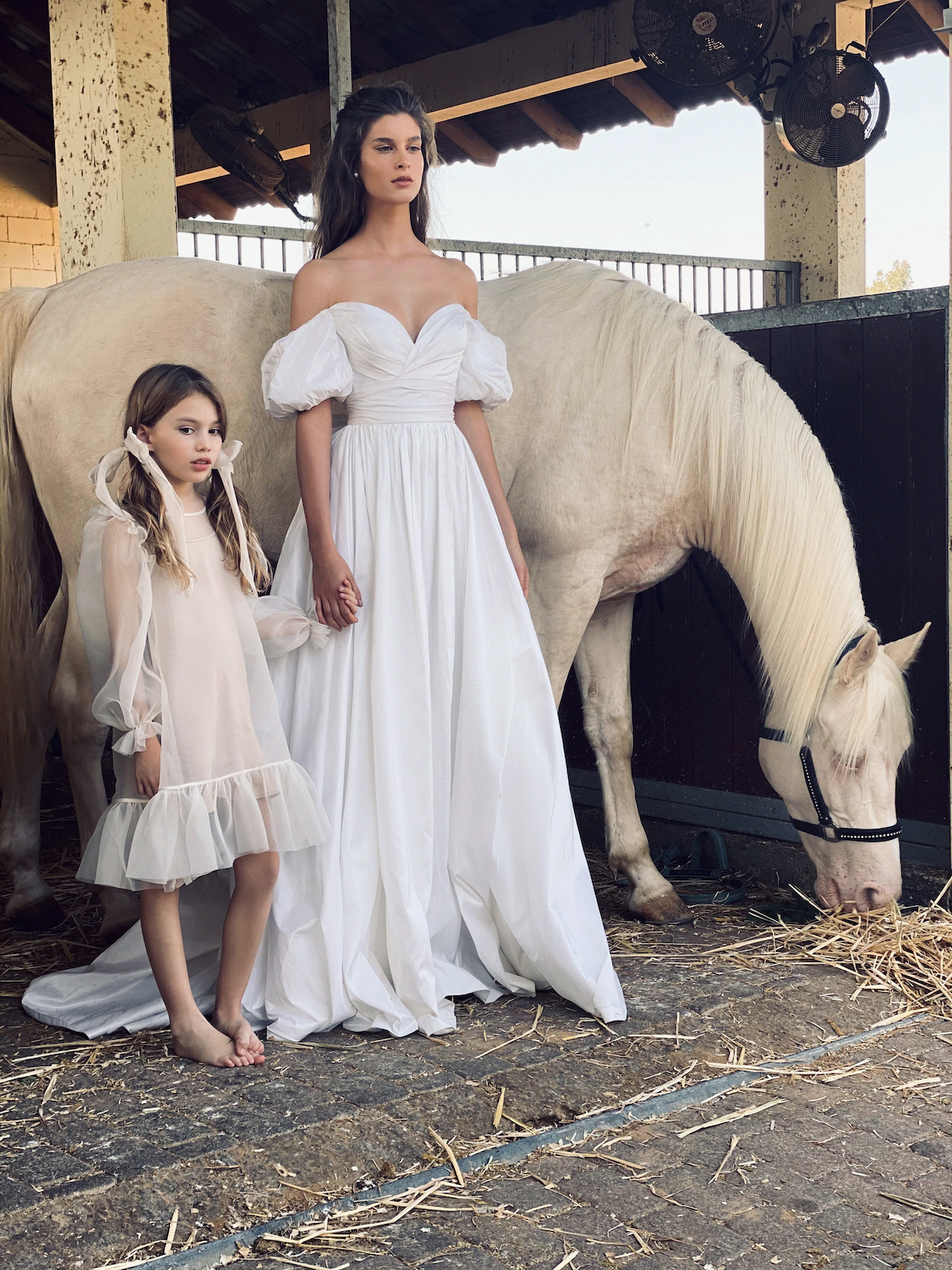 Off-the-shoulder puffy sleeve wedding dress on bride with flower girl 
