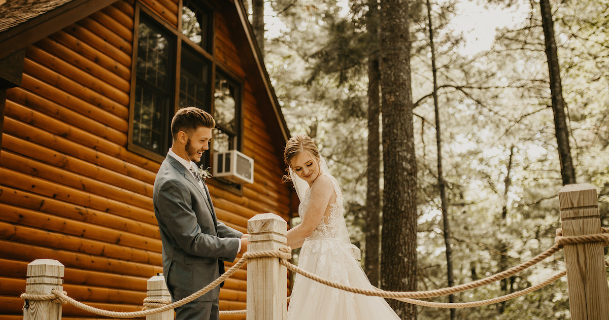 Bride and groom share first look before wedding ceremony in woods