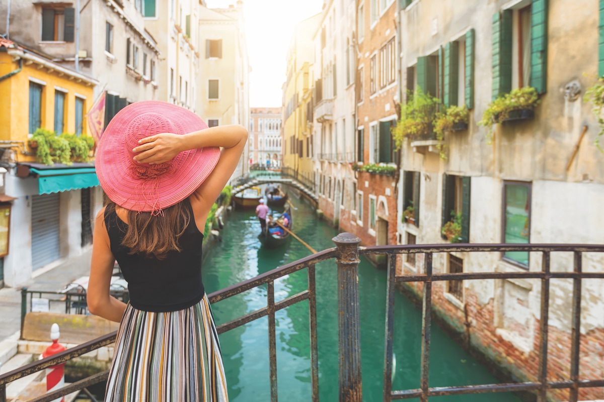 Girl in pink hat overlooks canal 