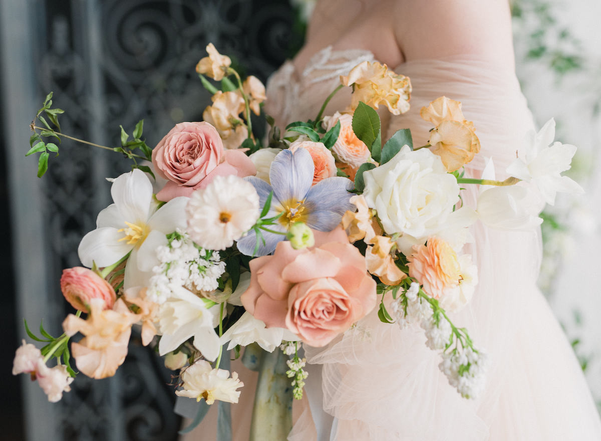 Spring bridal bouquet with peach, pink, and blue pastels 