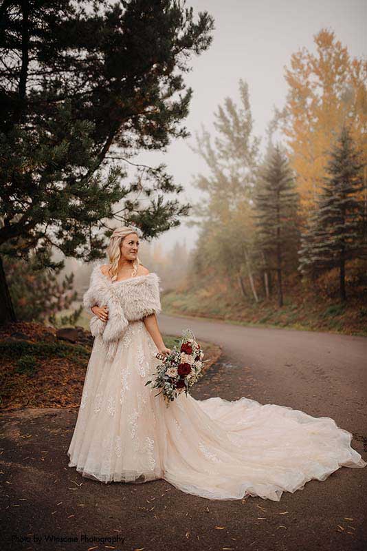 Bride in ballgown with fur wrap at outdoor fall wedding
