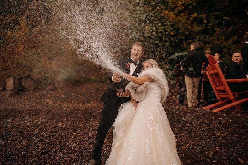 Bride and groom pop champagne