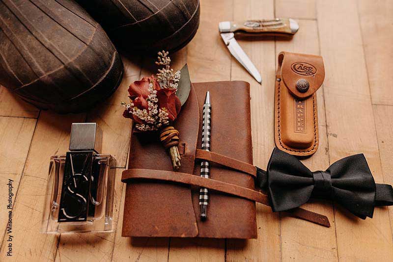 Groom's accessories with leather book, knife, bowtie, shoes