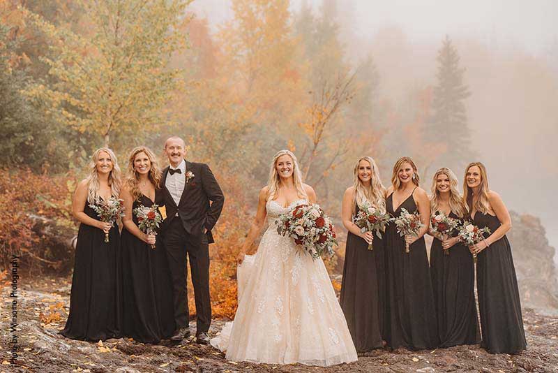 Bride stands with bridal party on the shores of Lake Superior