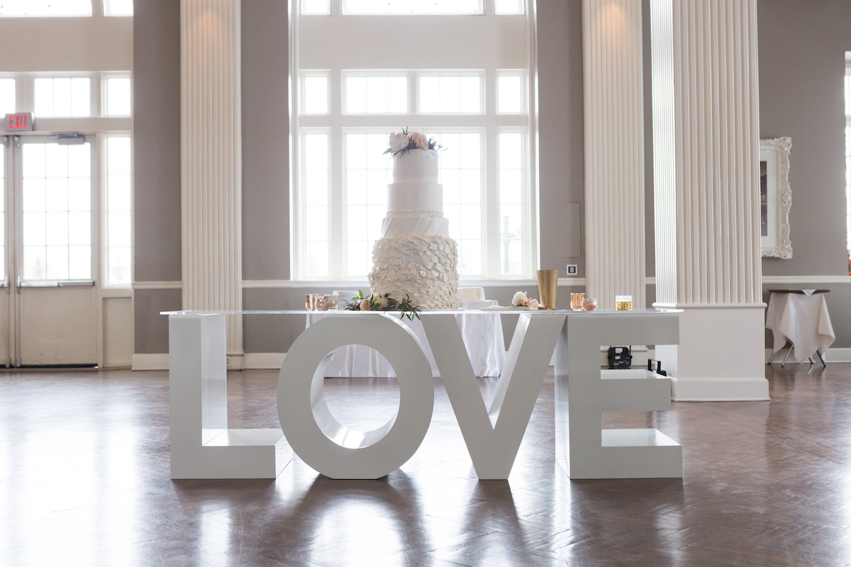 Wedding reception entrance with chiffon drapes and large "LOVE" letters
