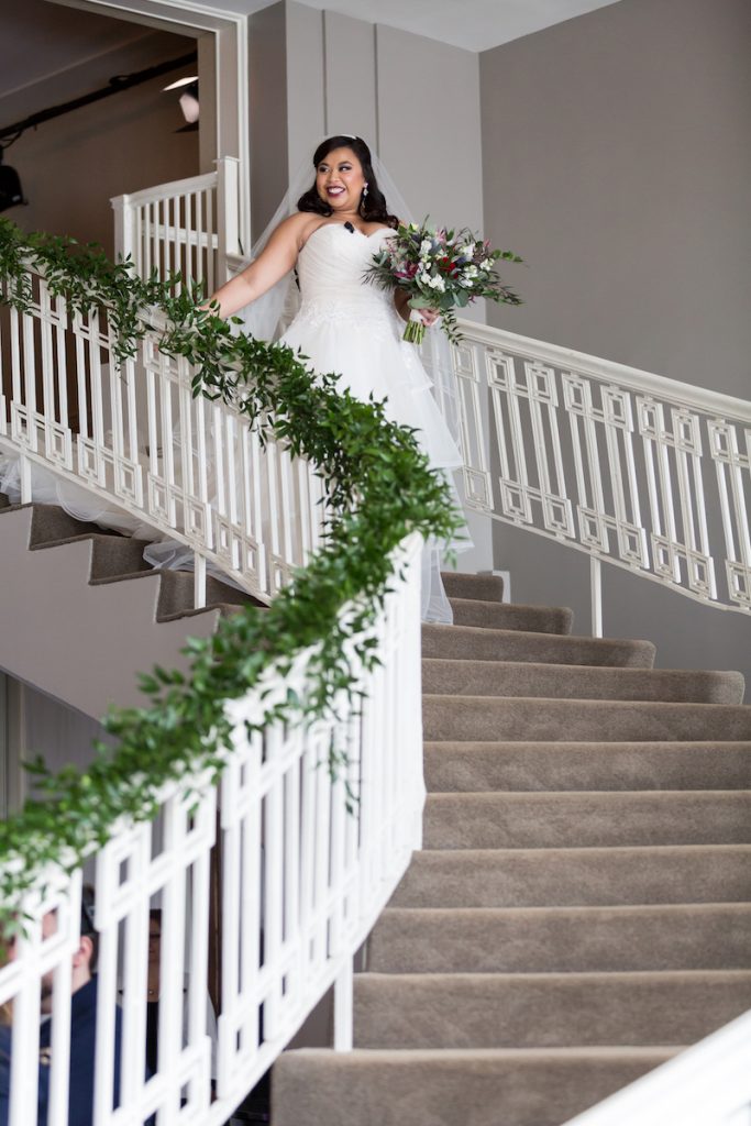 Bride in strapless gown walks down staircase