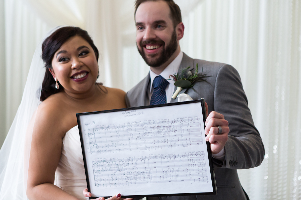 Couple holds wedding music in a frame