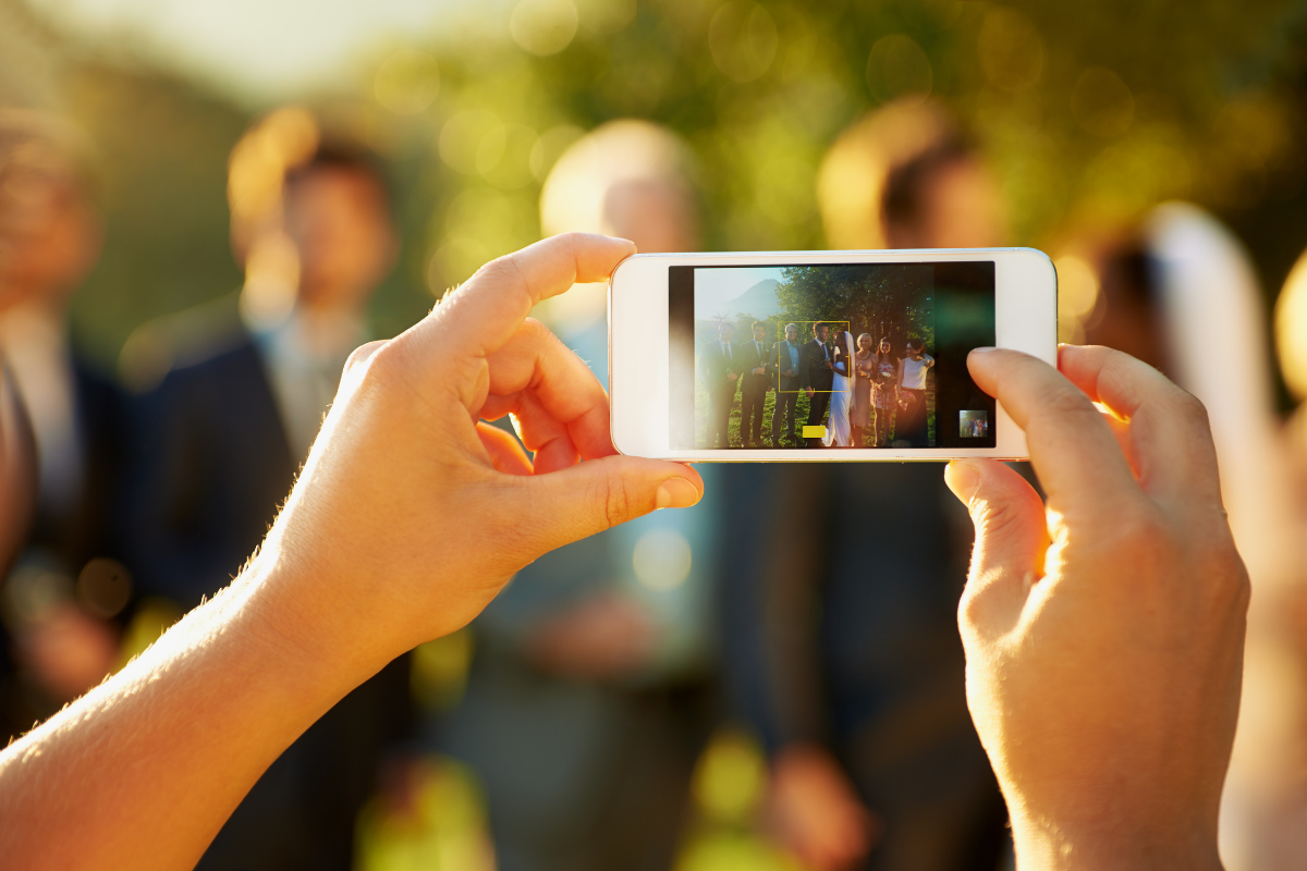Guest takes image at wedding following wedding social media etiquette 
