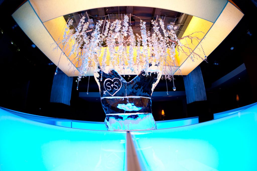 Custom acrylic wedding bar with hanging floral from ceiling and an ice sculpture