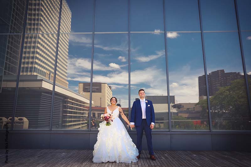 Groom wearing blue suit and bride in white dress