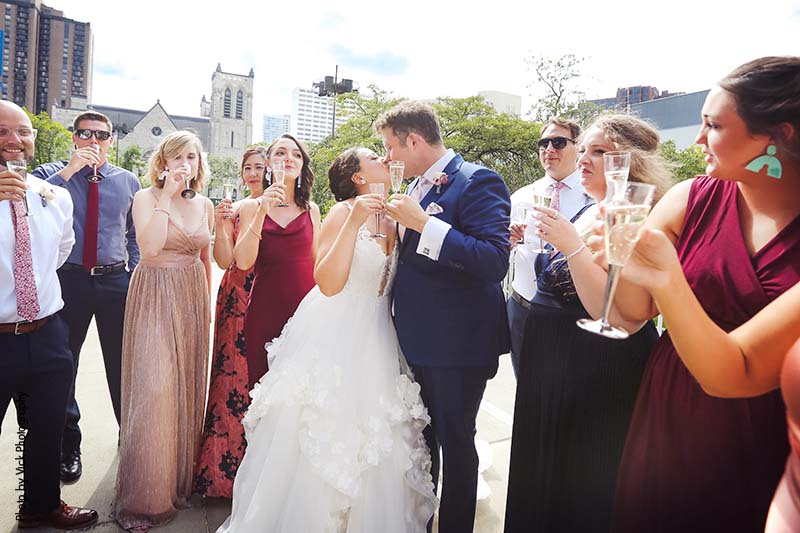 Bride and groom kiss during a wedding party toast
