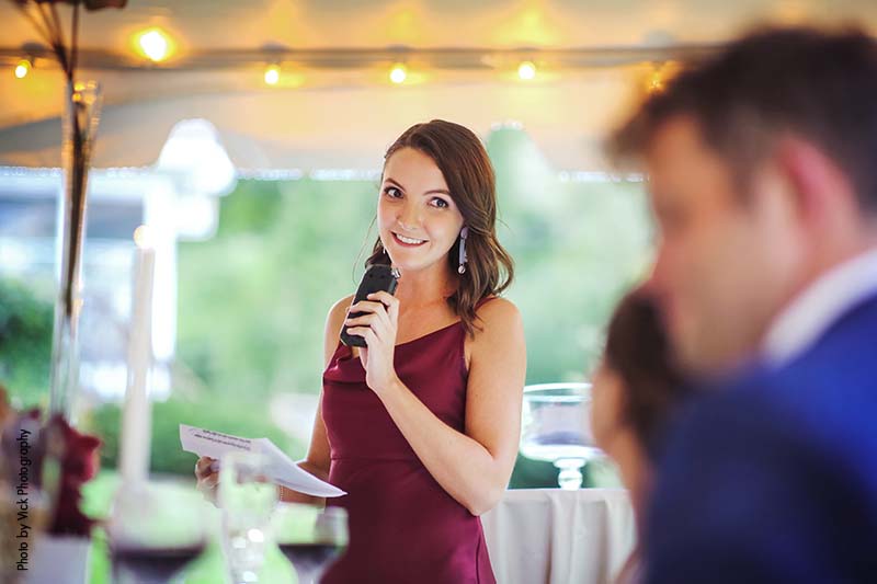 Maid of honor giving speech at backyard wedding reception
