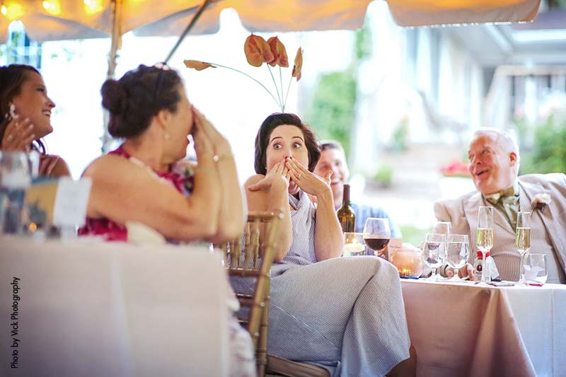 Guests react to speeches at backyard wedding reception